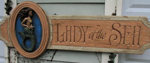 seaside vintage signs mermaid sculptures